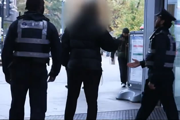 A suspected fare dodger walks away from enforcement officers at Ealing Broadway