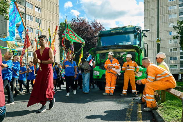 Workmen in Roehampton take a break to watch the parade 