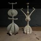 A couple of white sculptures on a wooden surface  Description automatically generated